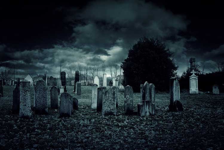 A creepy looking graveyard at night.
