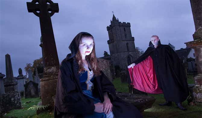 Two Stirling Ghost Walk guides in a graveyard.
